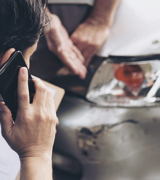 Insurance agent working during on site car accident claim process - people and car insurance claim concept